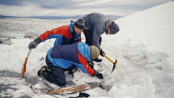 Her fjernes isen over skien forsiktig med isøks.